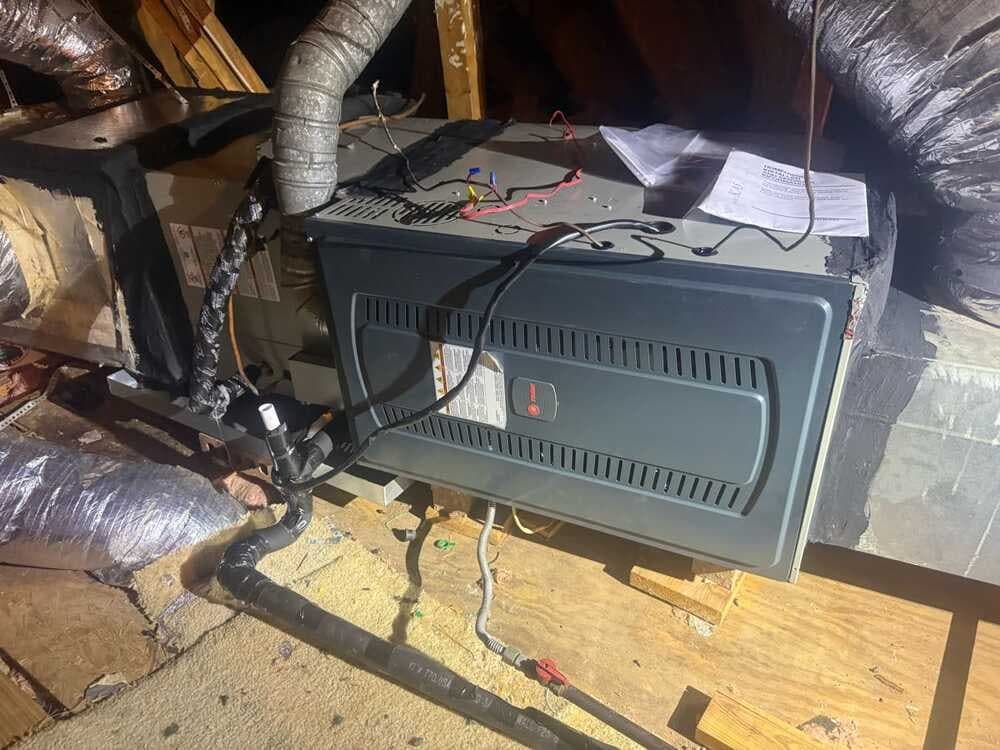 Indoor HVAC unit installed in an attic with new ductwork and wiring connected