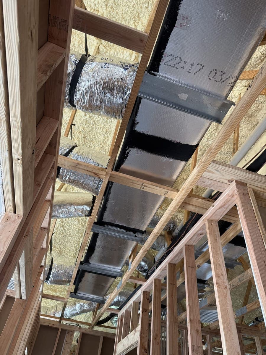 New foil-faced supply trunk with insulated flex branches running through open framing